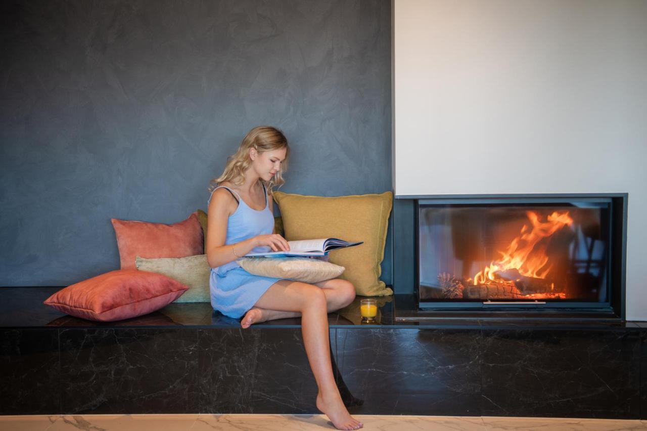 Galaxy Boutique Hotel Lake Tekapo Kültér fotó A woman reading a book by a fireplace